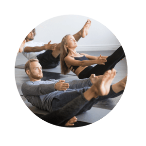 Group of men and women  doing yoga at a studio