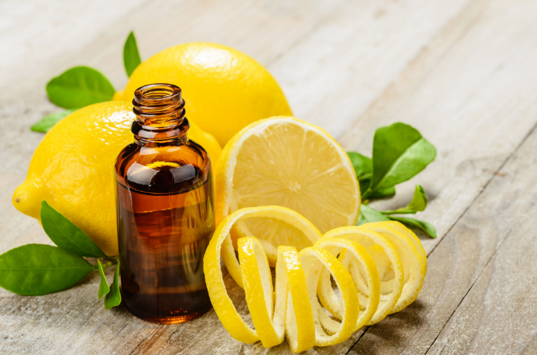 lemon essential oil with fresh lemons and lemon peel