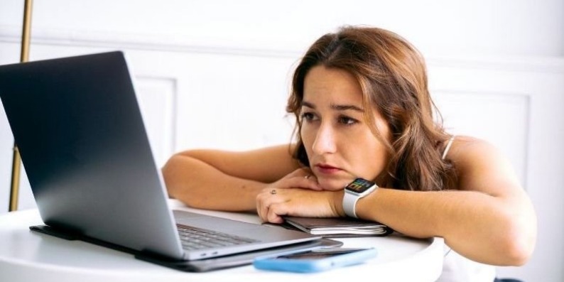woman at the computer looking emotionally exhausted
